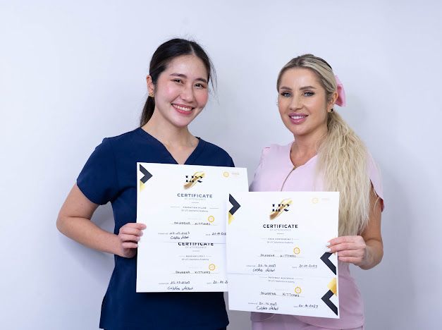 dr cristina and trainee displaying certificates